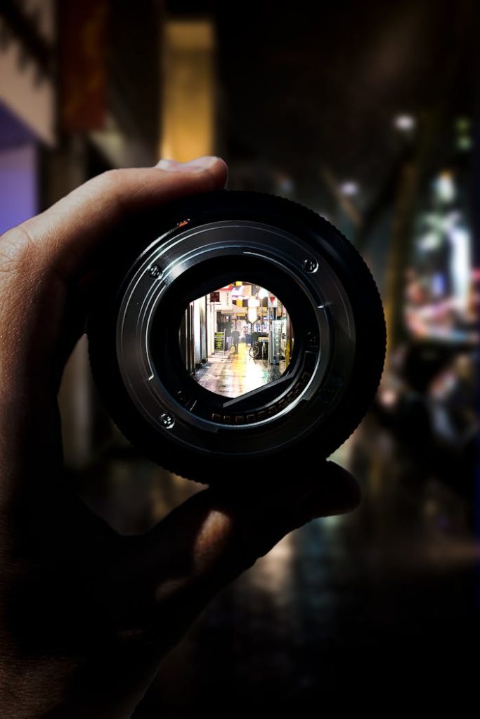 Person Holding Black Camera Lens